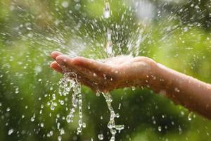 Wet female hands and clear water splashes photo