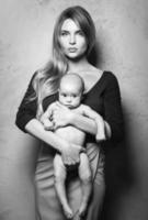 hermosa madre bien vestida con su lindo bebé en sus manos foto