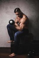 Massive bodybuilder doing biceps curl exercise with the dumbbell photo