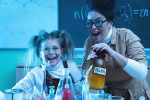 profesor y niña durante la lección de química mezclando productos químicos en un laboratorio foto