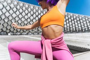 Carefree active woman dancer wearing colorful sportswear having fun on the street photo