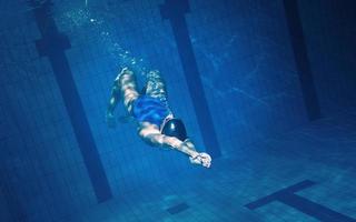 mujer nadadora bajo el agua durante su entrenamiento en la piscina foto