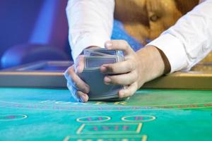Professional croupier during cards shuffle in casino photo