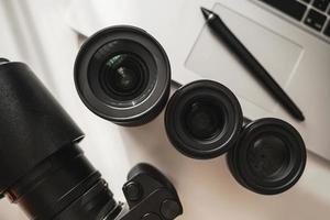 Workplace with a modern equipment for photography. Mirrorless camera and prime lenses. photo