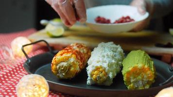 elote de maíz mexicano en tres formas. prensado con queso, guacamole y granada. bandera maxicana video