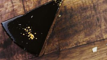 Banana chocolate cake with gold dust on a wooden tray with decorations video