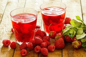 Refreshing drink with raspberry and strawberry on wooden table photo