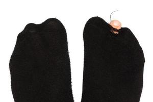 Closeup shot of male feet in hoaly socks with sticking out toe. photo