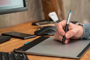 Closeup of male hands during using a graphic tablet photo