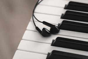 Closeup of earphones over piano or synthesizer keyboard