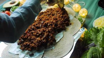 mengen de ingrediënten voor de chorizo en de bewaard gebleven tomaten met een houten lepel. macro het schieten video