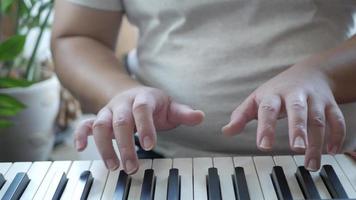 close up view to hand while playing piano keyboard classic musical instrument with selective focusing