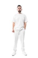 hombre guapo con ropa blanca con un espacio en blanco para el diseño sobre fondo blanco foto
