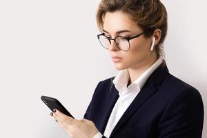 Young businesswoman talking by phone using wireless earbuds photo