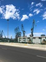 Industrial shipyard for ships in the port with large iron cranes for loading and unloading cargoes near the road photo