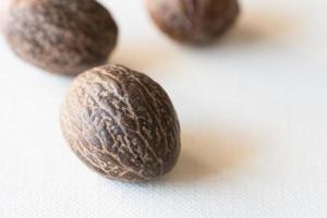 Whole Nutmeg on a White Background photo