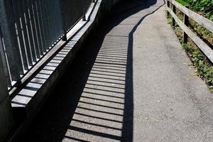 Shadow of Fence on Ground in the Park. photo