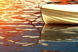 barco blanco en el agua al atardecer. imagen horizontal foto