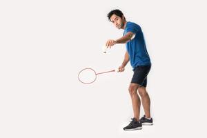 A badminton player in sportswear stands holding a racket and shuttlecock. photo