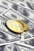 los bitcoins dorados yacen en muchos billetes de dólar. el concepto de elevar el precio de bitcoin en relación con el dólar estadounidense foto