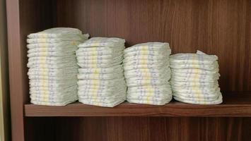 Baby diapers stacked on the shelf. photo