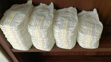 Baby diapers stacked on the shelf. photo