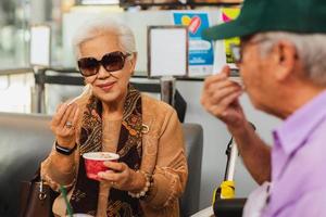 feliz pareja senior disfruta comiendo helado. foto