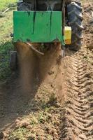 Harvesting in the village, harvesting potatoes with a tractor with a plow and a vibrating screen. photo