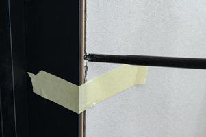 The use of painter's tape in the installation of the door, the tape restrains the deformation of the door during the filling of the gaps between the door and the wall with foam. photo