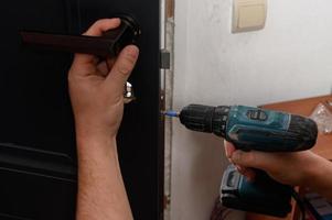 Installation of a door handle on interior doors, carpentry work with doors. photo