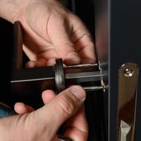 A man installs a doorknob in a door, carpentry at home. photo