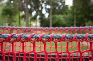 Playground for active games and entertainment, outdoors. Red mesh on a cable for the safe movement of the child. photo