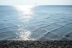 Sea with unusual square waves near the shore, against the blue sky. Beautiful spring landscape. photo