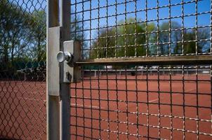 la entrada al campo de deportes está cercada con una cerca de alambre soldado y una puerta, en. concepto de un estilo de vida saludable y activo. foto