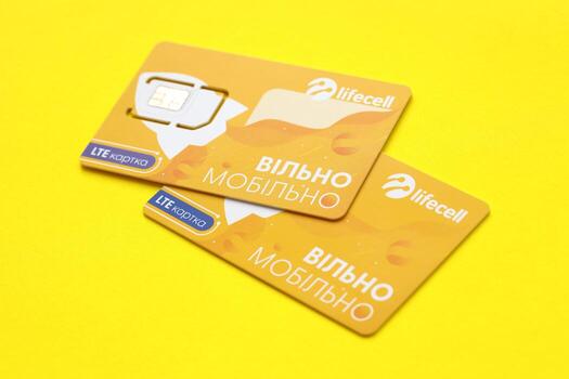 TERNOPIL, UKRAINE - JULY 5, 2022 Lifecell new sim card with free contract on yellow background. Lifecell is ukrainian mobile telephone network operator and provider of wireless connection photo