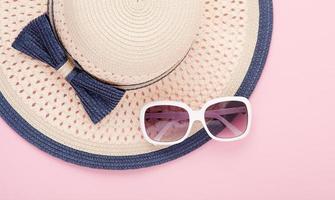 Summer hat with ribbon and sunglasses isolated on colorful background. Top view and copy space. photo