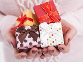 Hands holding paper gift boxes with as present for Christmas, new year, valentine day or anniversary close up. photo