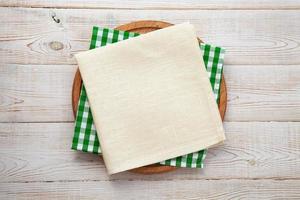 Empty pizza board and napkin on white wooden top view. photo
