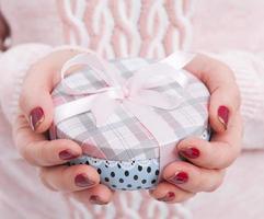 manos de mujer envolviendo navidad, regalo de vacaciones hecho a mano en caja de papel con cinta roja. dar caja de regalo, decoración de regalo foto