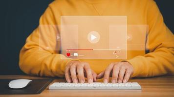 Man using mouse and keyboard for streaming online on virtual screen, searching video on internet, live football, show or tutorial, watching the movies, content online. photo