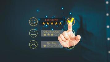 Man touching the virtual screen on the happy smiley face icon to give satisfaction in service. Rating very impressed. Customer service, testimonial satisfaction concept. photo