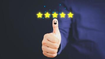 Pulgar hacia arriba por la emoción positiva y el icono de cara sonriente de cinco estrellas con espacio de copia. satisfacción del cliente y concepto testimonial. foto