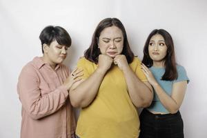 A portrait of three friends looking sad crying wiped her tears and hug each other, isolated white background photo