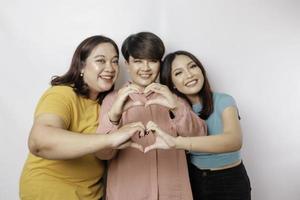 tres mujeres asiáticas se sienten felices y un gesto de corazón de formas románticas expresa sentimientos tiernos, concepto de amistad cercana. foto