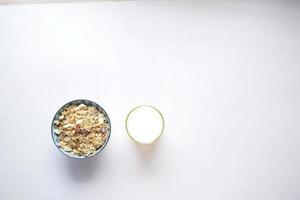vista superior de granola musli en un tazón y leche en la mesa foto