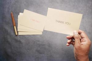 close up of man hand reading a thank you letter photo