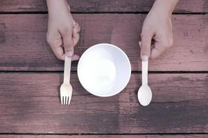 cutlery and empty plate on wooden background top down photo