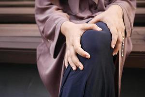 Cerrar sobre las mujeres que sufren dolor en las articulaciones de la rodilla foto