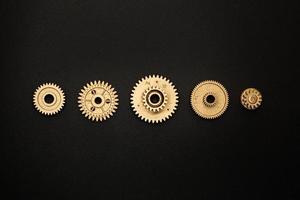 template of five golden gears on black background photo