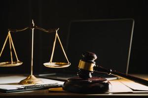 Business and lawyers discussing contract papers with brass scale on desk in office. Law, legal services, advice, justice and law concept photo